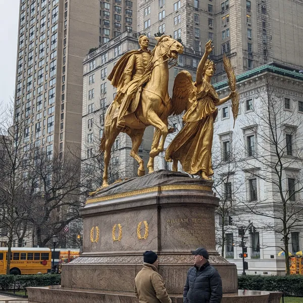 Golden statue of General Sherman riding a horse led by an angel