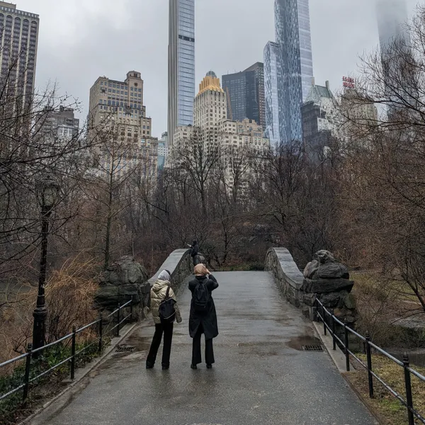 two girls taking pictures of the skyline